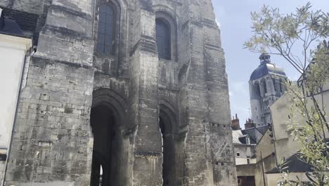 Tour-Charlemagne-and-Basilique-Saint-Martin-de-Tours-with-pedestrians-walking-on-a-sunny-street-in-Tours,-France