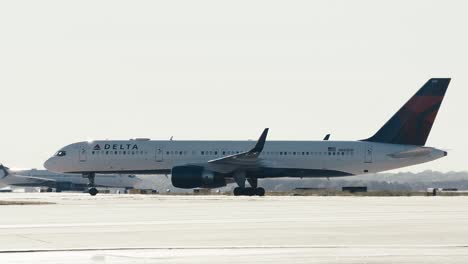 Wide-shot-of-a-commercial-Delta-Airplane-taxing-down-a-runway-at-ATL-airport-in-Atlanta-Georgia