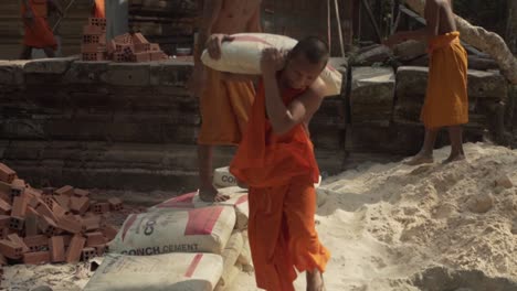 2-Young-buddhist-monks-working-and-building-a-monastery-at-Angkor-Wat---Siem-Reap,-Cambodia