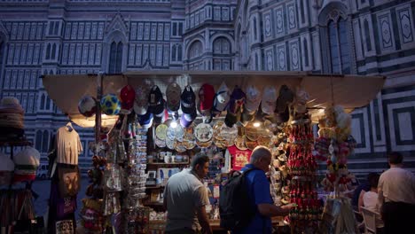 Puesto-De-Vendedores-Ambulantes-De-Recuerdos-Turísticos-En-Florencia,-Italia,-Vendiendo-Baratijas-Con-La-Catedral-De-Florencia-En-Segundo-Plano.