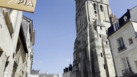 Calle-Adoquinada-Cerca-De-La-Emblemática-Torre-De-Tours-Carlomagno-En-La-Ciudad-De-Tours-Francia-Con-Peatones-Caminando-Y-Un-Letrero-En-La-Calle-Chez-Pia-En-Un-Día-Soleado-De-Verano