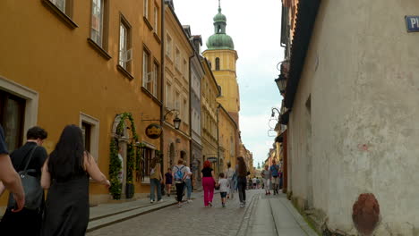 Los-Turistas-Caminan-Por-La-Calle-Piwna-En-Varsovia,-Cerca-De-La-Plaza-Del-Castillo,-La-Columna-De-Segismundo.