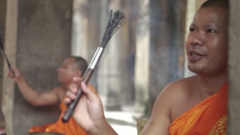 1-A-buddhist-monk-performing-blessing-ritual-ceremony-at-Angkor-Wat---Siem-Reap,-Cambodia