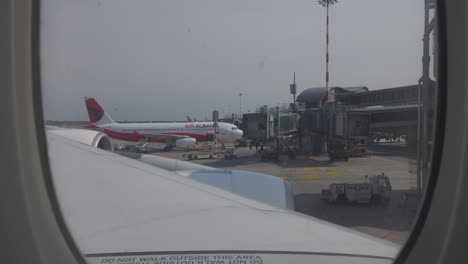 POV-Looking-Out-Plane-Window-As-It-Taxis-For-Departure-From-Terminal-Building