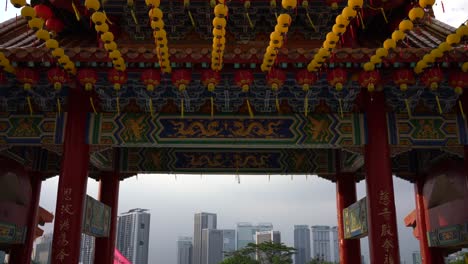 Vista-Inclinada-Hacia-Arriba-Con-Vistas-Al-Horizonte-Del-Paisaje-Urbano-Y-Las-Hermosas-Linternas-Amarillas-Que-Celebran-El-Cumpleaños-De-Mazu-En-El-Templo-Thean-Hou,-Kuala-Lumpur,-Malasia