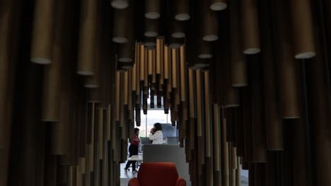 Slow-revealing-shot-of-large-cylinders-hanging-from-the-roof-with-a-seating-area