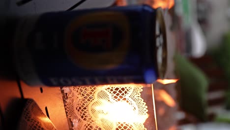 fosters-beer-can-in-front-of-a-gas-fireplace-with-glass-beads-and-railings-warm-feeling-VERTICAL