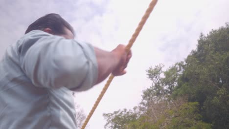 Witness-the-strength-and-teamwork-as-a-man-pulls-a-rope-to-move-a-bamboo-raft-between-locations