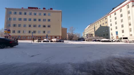 Helsinki's-snow-covered-streets-provide-a-stunning-backdrop-as-cars-gracefully-traverse-the-city's-charming-buildings,-creating-a-mesmerizing-winter-tableau