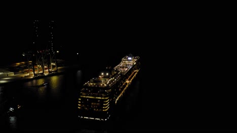 Cruise-ship-MSC-MUSICA-leaving-port-of-Montevideo-during-night-time-assisted-by-tug-boats