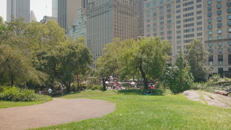 Statische,-Ruhige-Szene-Im-Central-Park-Mit-Gehweg-Und-Grasfläche-Am-Hang,-Dahinter-Die-Skyline