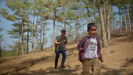 Father-and-child-chasing-together-in-wild-nature-at-sunny-day