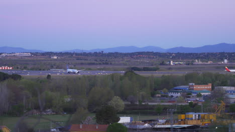 Plane-taking-off-at-sunrise-with-mountains-in-the-background