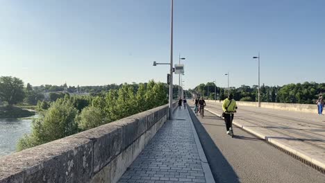 Ciclistas-Y-Scooters-Eléctricos-En-Cámara-Lenta-Pasando-Por-El-Puente-Wilson-En-Tours,-Francia.