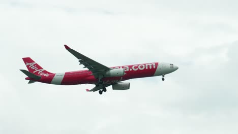 Preparing-for-landing,-the-AirAsia-A330-lowers-its-landing-gear-as-it-descends-at-Don-Mueang-International-Airport,-in-Bangkok,-Thailand