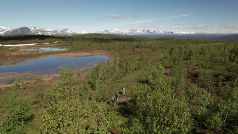 Superweite-Luftaufnahme-Von-Drei-Wanderern,-Die-Auf-Dem-Kungsleden-Weg-In-Einer-Atemberaubenden-Schwedischen-Berg--Und-Tundralandschaft,-Lappland,-Tsielekjåkk,-Sonniger-Tag,-Spazieren