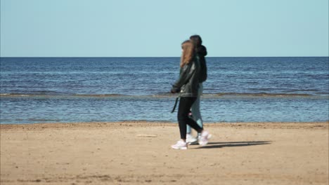 Sanfte-Wellen-Am-Strand-Von-Jurmala,-Lettland,-Mit-Ein-Paar-Mädchen,-Die-Vorbeikommen