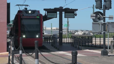 Toma-De-Un-Tren-Del-Metro-De-Houston-Que-Se-Desplaza-De-Izquierda-A-Derecha-Mientras-Pasa-Por-La-Estación-UHD-En-Main-Street-En-Houston,-Texas.