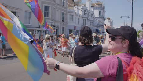 Mujer-Ondea-La-Bandera-Del-Arco-Iris-En-El-Desfile-Del-Orgullo-Gay-En-La-Isla-De-White-2018-Mientras-Los-Bateristas-Desfilan