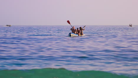 Gente-Sentada-En-Kayak-Y-Tablas-De-Remo-Con-Lanchas-A-Motor-Pasando-Al-Fondo