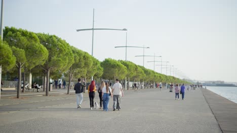 Vida-En-La-Ciudad-Gente-Caminando-Junto-Al-Mar-Paseo-Marítimo-De-La-Playa-De-Tesalónica-Día-Soleado-De-Verano