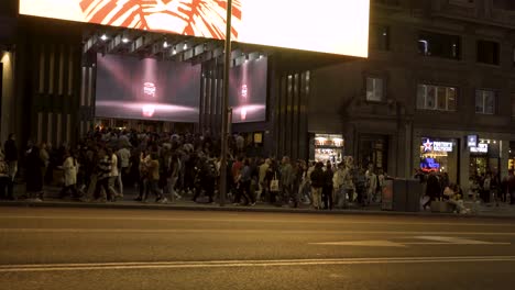 Night-shot-Gran-Vía-street-in-Madrid-with-crowded-sidewalk-and-entrance-to-theater