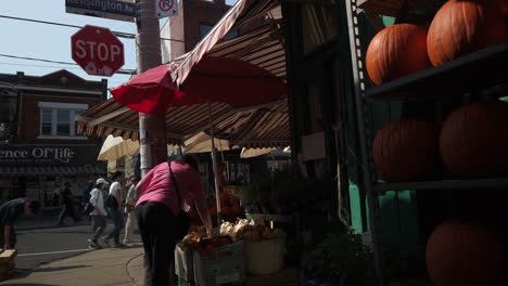 Plano-General-De-Una-Mujer-Comprando-Comestibles-En-Un-Concurrido-Puesto-De-Verduras-Del-Mercado-De-Kensington