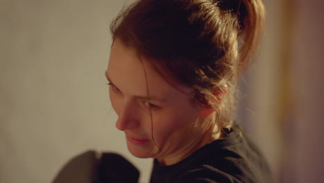 closeup-of-a-boxing-girl-with-a-focused-face-punching-on-a-punching-bag-with-attitude