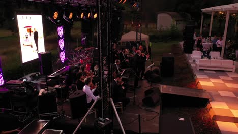 Orchestra-playing-at-a-wedding-party-while-guests-watch