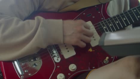 Primer-Plano:-Un-Hombre-Toca-Una-Guitarra-Fender-Jaguar-Roja-Con-Pastillas-Eléctricas