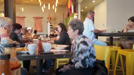 Un-Restaurante-Durante-El-Desayuno,-Donde-Dos-Señoras-Mayores-Conversan-Animadamente-Y-Comparten-Historias-Durante-El-Desayuno