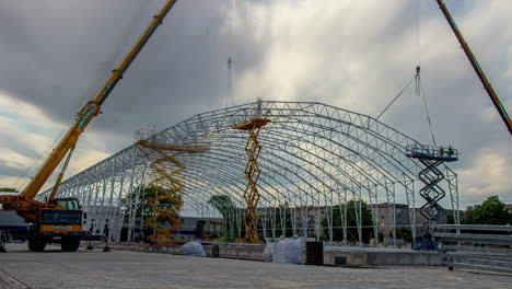 Time-lapse-of-heavy-machinery-building-a-industrial-hall-frame-construction-site