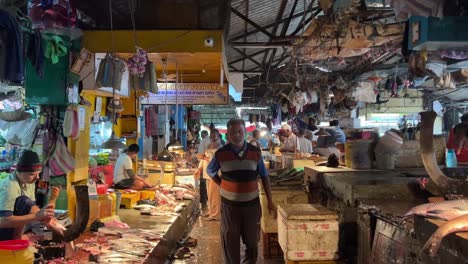 Shot-of-a-people-walking-around-buying-fish-in-a-local-indoor-fish-market-in-Kolkata,-India-at-daytime