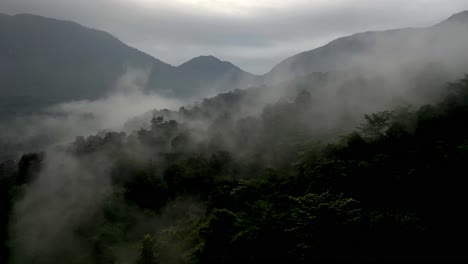 Aerial-drone-view-camera-moving-forward-where-fog-is-visible-above-and-mountains-are-also-visible