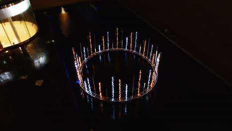 Aerial-of-beautiful-light-fountain-in-Utrecht-city-center,-the-Netherlands-at-night