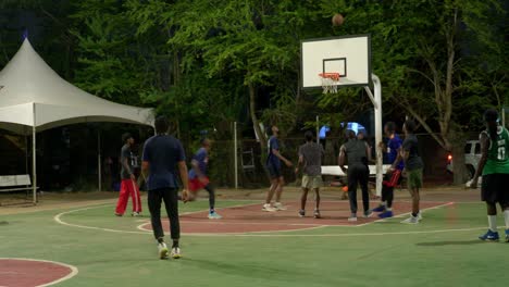 Los-Atletas-Negros-Juegan-En-Equipo-En-Canchas-De-Baloncesto-Al-Aire-Libre-Por-La-Noche-En-África.