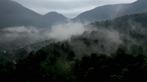 Aerial-drone-view-drone-camera-moving-forward-where-fog-is-visible-above-and-mountains-are-also-visible