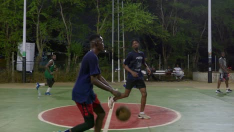 Cámara-Lenta-De-Atletas-Negros-Juegan-Baloncesto-Al-Aire-Libre-Por-La-Noche-Como-Equipo