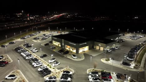 Vista-Aérea-Nocturna-De-Un-Concesionario-De-Automóviles-Jaguar-Y-Land-Rover-Escuchar-Una-Carretera