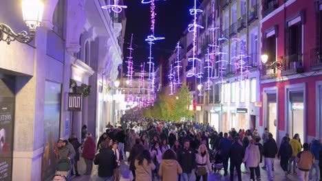 People-walk-through-a-crowded-pedestrian-street-illuminated-with-Christmas-purple-lights-during-the-Christmas-holiday