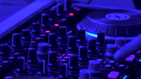 Close-Up-of-DJ-Mixing-Music-on-mix-table-in-the-Nightclub-with-Partner-Party-Bracelet