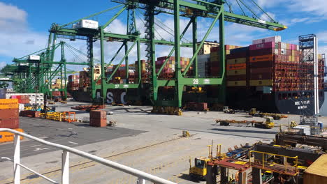 Panama-Port-Terminal,-Industrial-Cranes-Loading-Containers-on-Freight-Container-Ship---Elevated-View