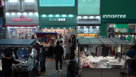 La-Gente-Compra-Comida-Callejera-En-Puestos-En-El-Mercado-Nocturno-De-Myeongdong-En-El-Centro-De-La-Ciudad-De-Seúl-En-Invierno.