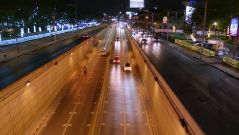 Tunnel-close-to-the-city-with-a-lot-of-cars-moving-at-night-in-Bangkok,-Thailand
