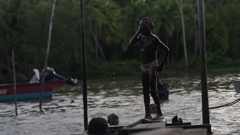 Ein-Mädchen-Und-Mehrere-Jungen-Vergnügen-Sich-Beim-Spielen,-Springen-Und-Schwimmen-In-Der-örtlichen-Weisheit-Des-Distrikts-Asmat,-Papua