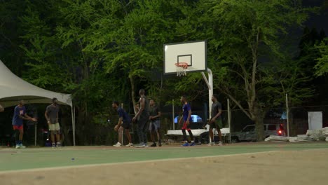 Tiro-De-ángulo-Bajo-Del-Equipo-De-Baloncesto-Negro-De-Ensueño-De-Amigos-Jugando-Juntos-Por-La-Noche