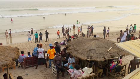 Pueblo-Africano-Reunido-Al-Atardecer-En-La-Playa-De-Sakumono-En-La-Costa-De-África-Occidental.