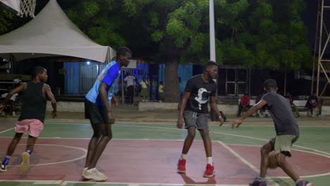 El-Equipo-De-Amigos-Negros-De-Baloncesto-Juega-Juntos-Por-La-Noche-En-La-Ciudad-De-África