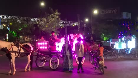 Cinematic-sot,-night-time-people-waiting-to-board-horse-carriage-ride-on-racecourse-ring-road