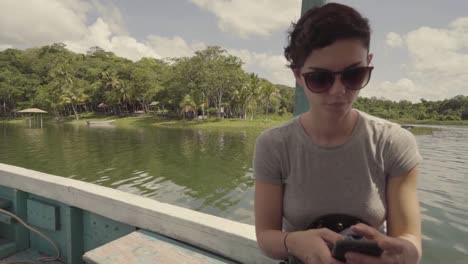 Chica-Dentro-De-Un-Barco-Enviando-Mensajes-De-Texto-Por-Teléfono-Móvil-Mientras-El-Barco-Se-Mueve